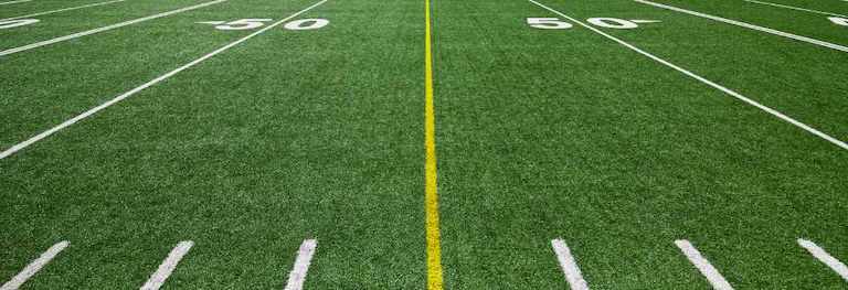 artificial turf close up on the 50 yard line with yellow center line