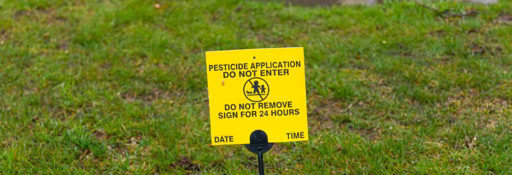 Caution: Pesticide Application Warning On Green Lawn